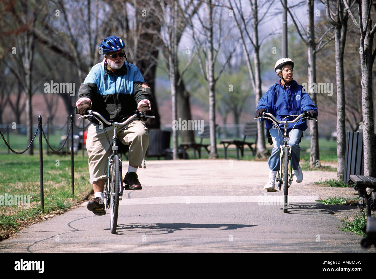 Una coppia di anziani biciclette passeggiate attraverso un parco pubblico in primavera a Washington DC Foto Stock