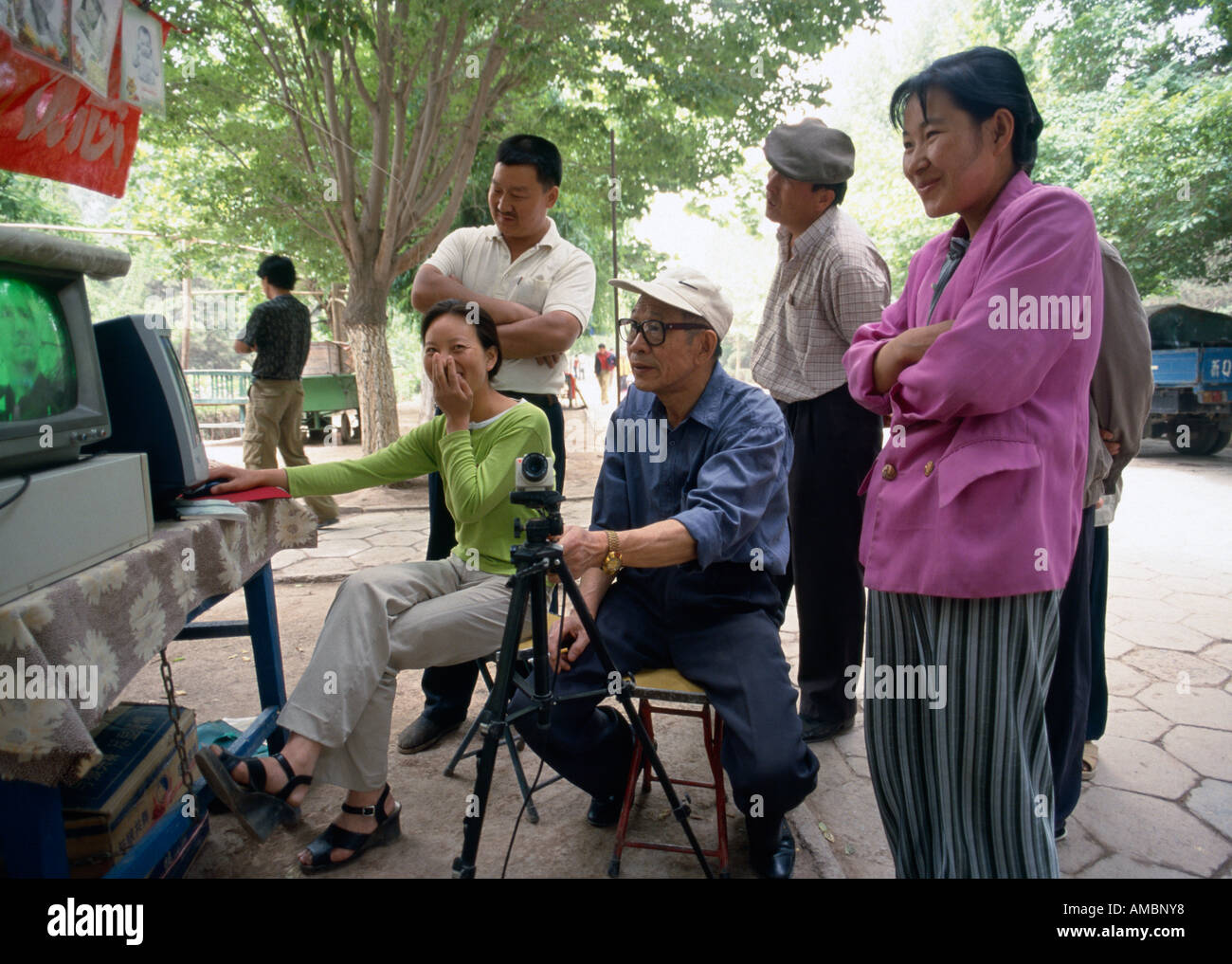 Gli spettatori a guardare video sullo schermo del televisore nel parco statale, Kashgar, Xinjiang, Cina Foto Stock