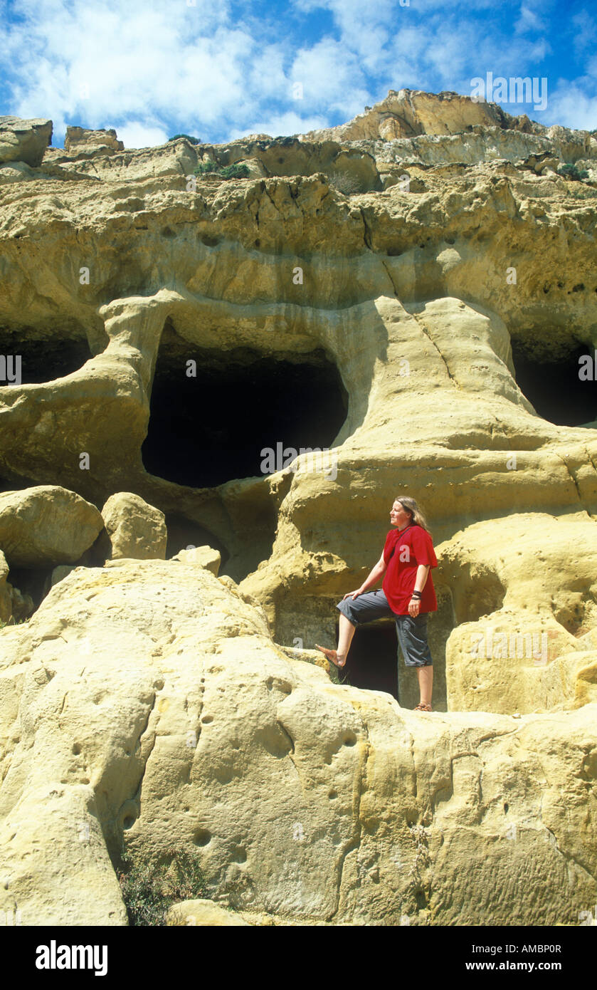 Giovane donna visitando le grotte di pietra calcarea nei pressi di Matala sull'isola greca di Creta Foto Stock