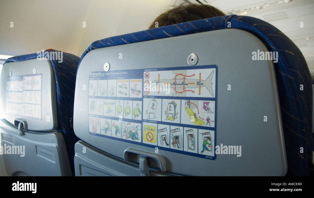 Retro del poggiatesta del sedile su aereo con emergenza istruzioni di  sicurezza Foto stock - Alamy
