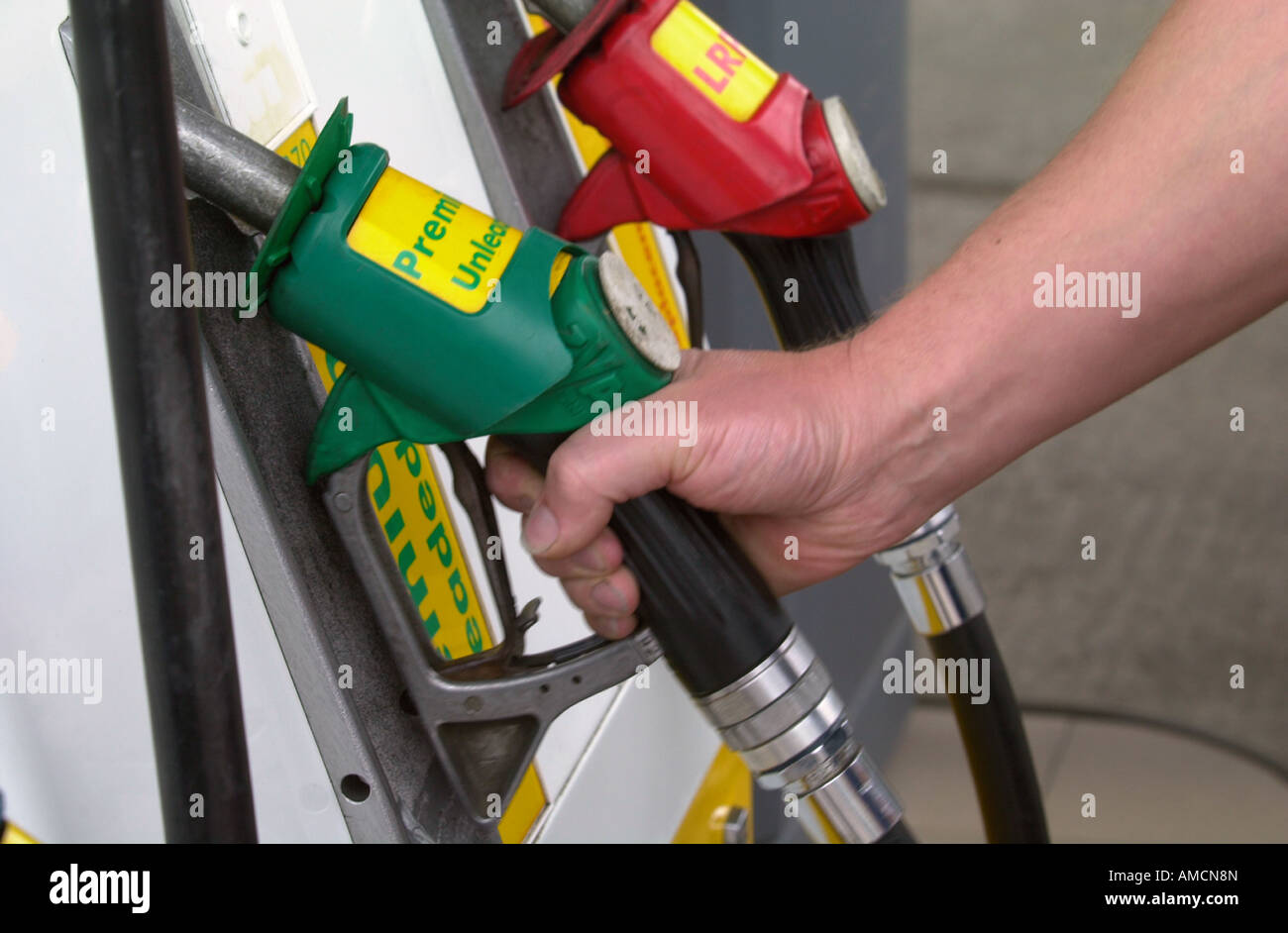 Dettaglio di un automobilista mano tenendo UNA BENZINA SENZA PIOMBO UGELLO DELLA POMPA DI REGNO UNITO Foto Stock