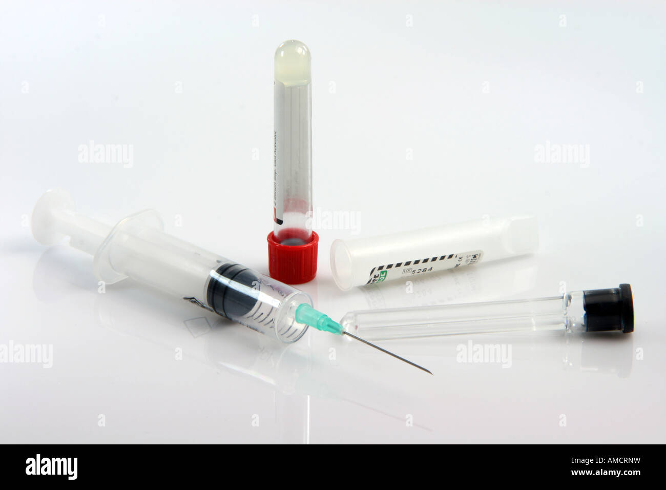 Il prelievo di campioni di sangue di apparecchiature con siringa evacuato tubi di plastica su sfondo bianco Foto Stock