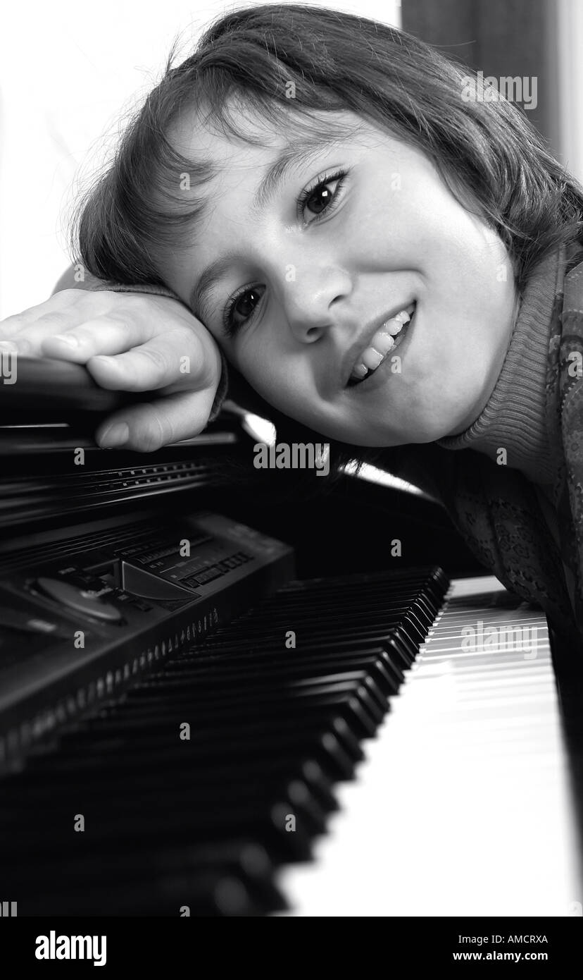 Ragazza appoggiata sul piano vicino fino B W Foto Stock