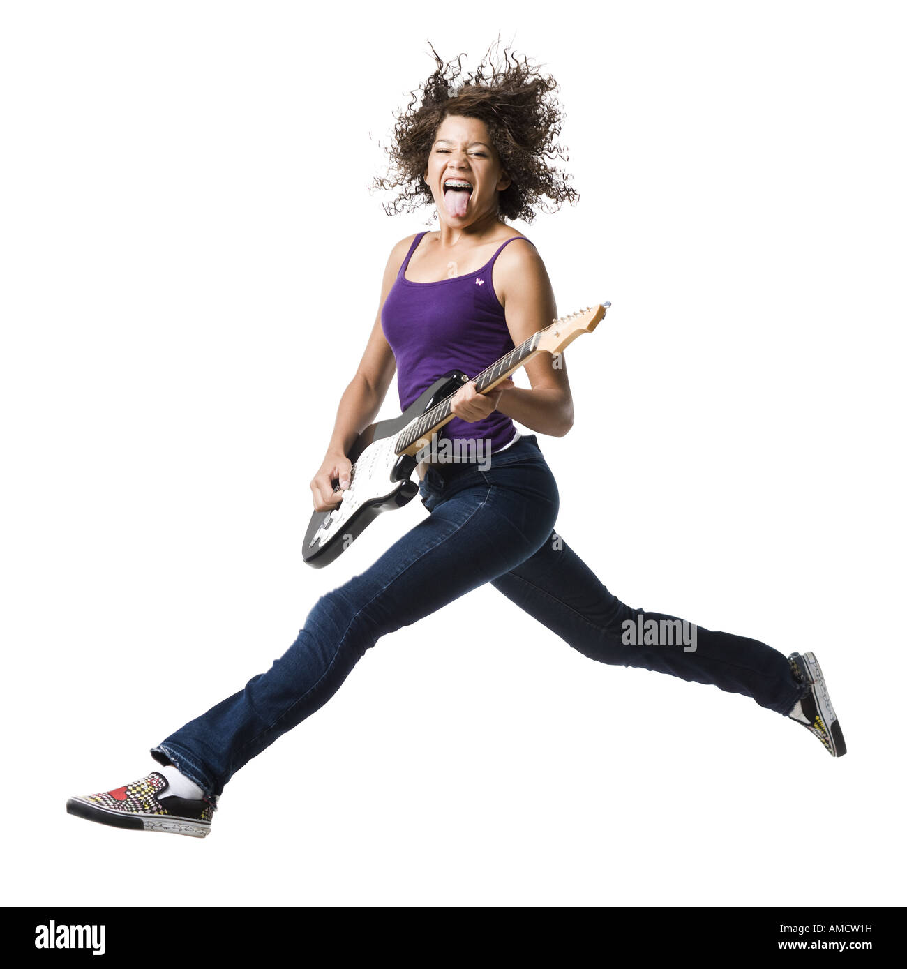 Ragazza con bretelle e chitarra che saltava e con la lingua fuori Foto Stock Ragazza con bretelle e chitarra che saltava e con la lingua fuori Foto Stock
