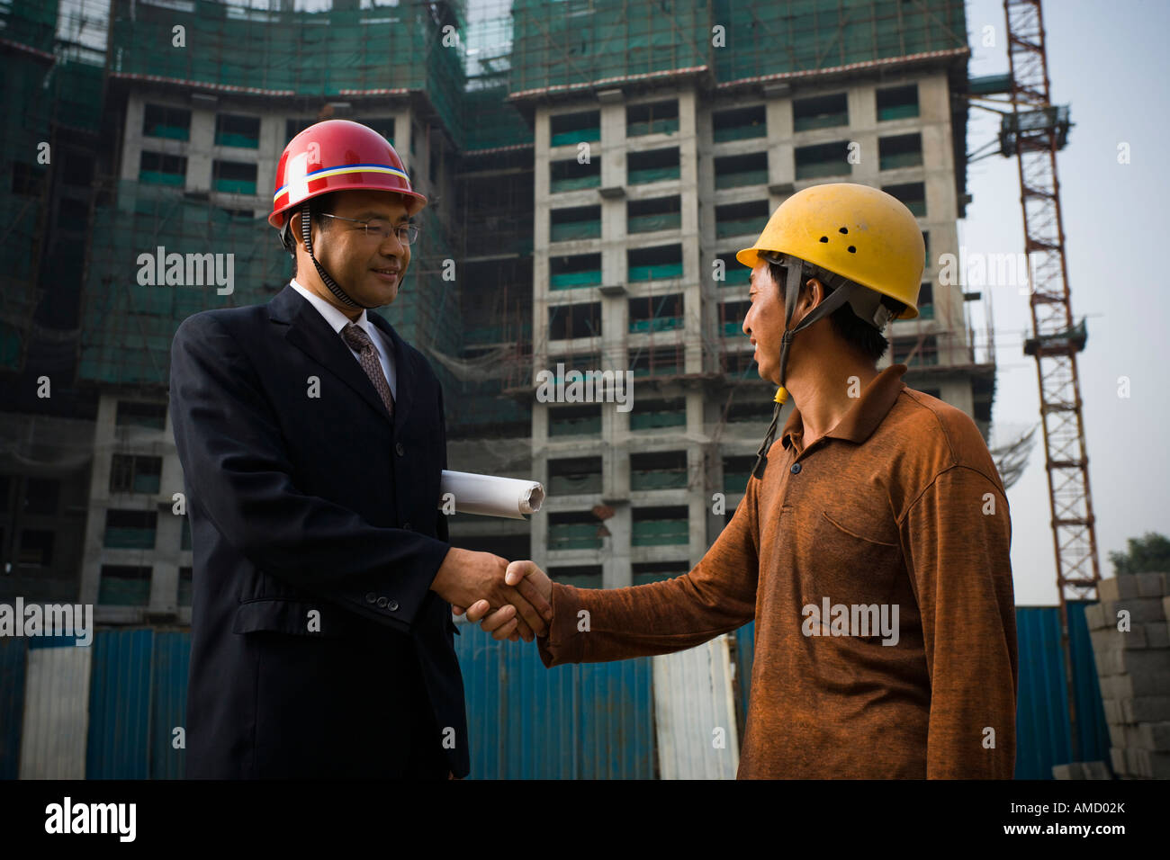 Costruzione caposquadra e lavoratore esterno stringono le mani Foto Stock