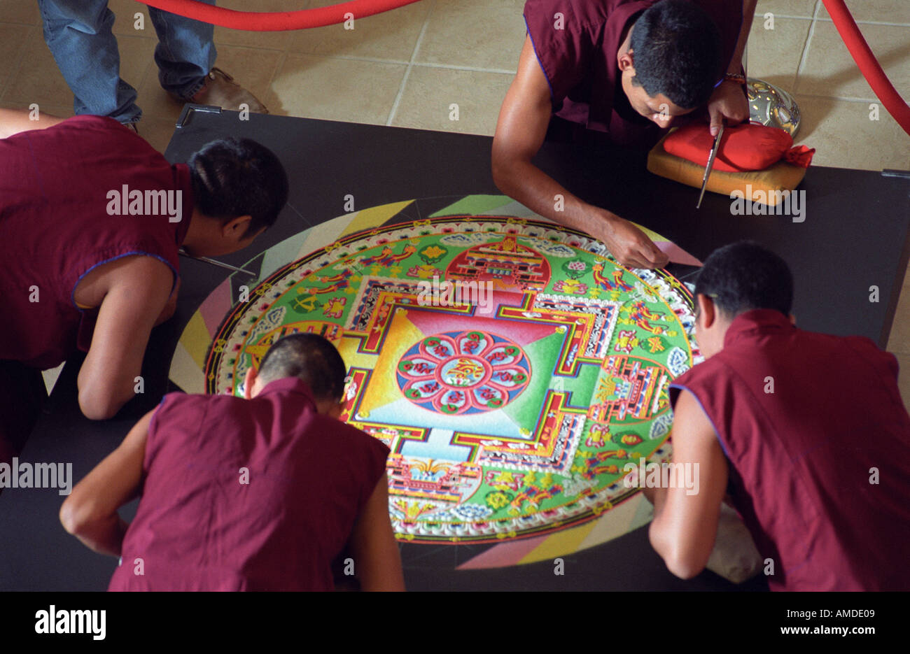 Quattro i monaci di lavoro su un quasi completato mandala Foto Stock