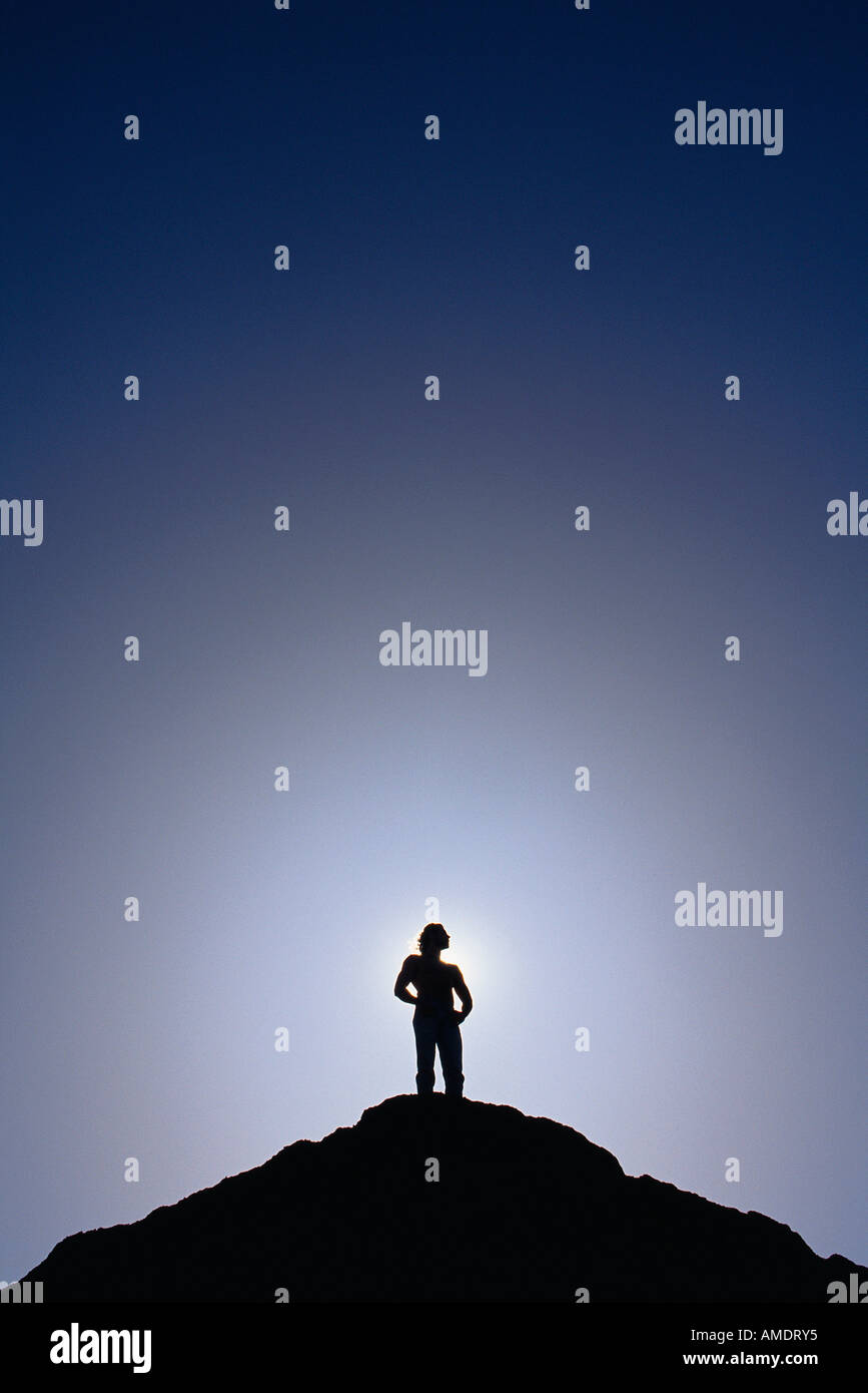 Silhouette di un uomo in piedi sulla cima della montagna Foto Stock