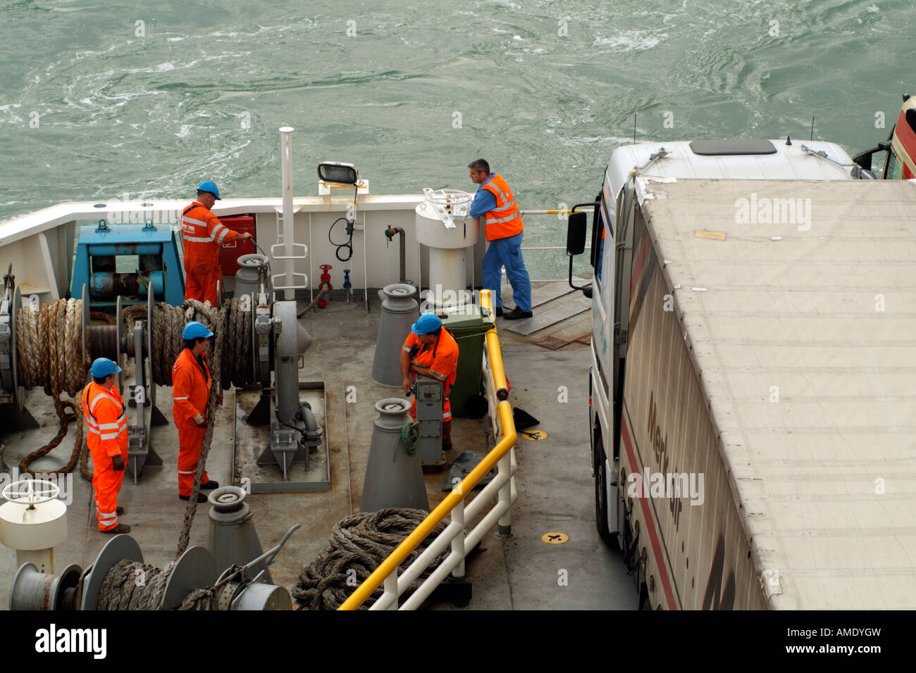 Equipaggio delle navi Winching funi di ormeggio sulla poppa di Cross Channel camion traghetto sistemati sul ponte Foto Stock
