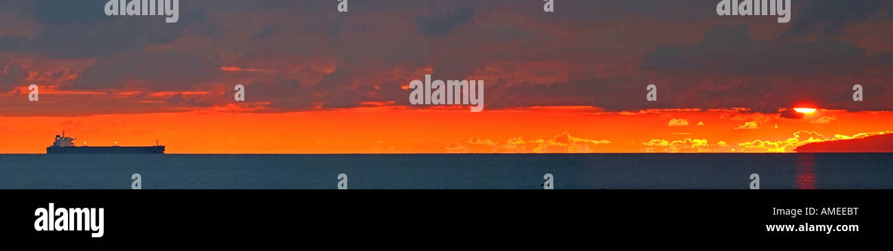 Tanker all'orizzonte come il sole tramonta sul Firth of Clyde Foto Stock