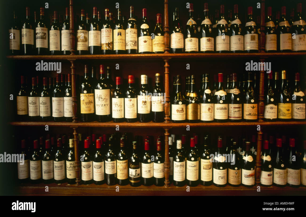Una selezione di bottiglie di vino su scaffalature di legno in un negozio di Parigi Foto Stock