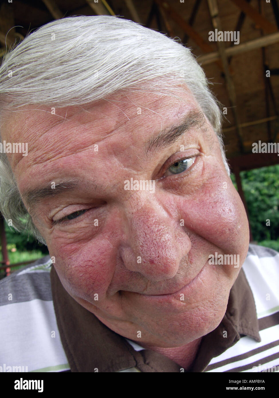 Il vecchio uomo Rendendo divertente volto Foto Stock