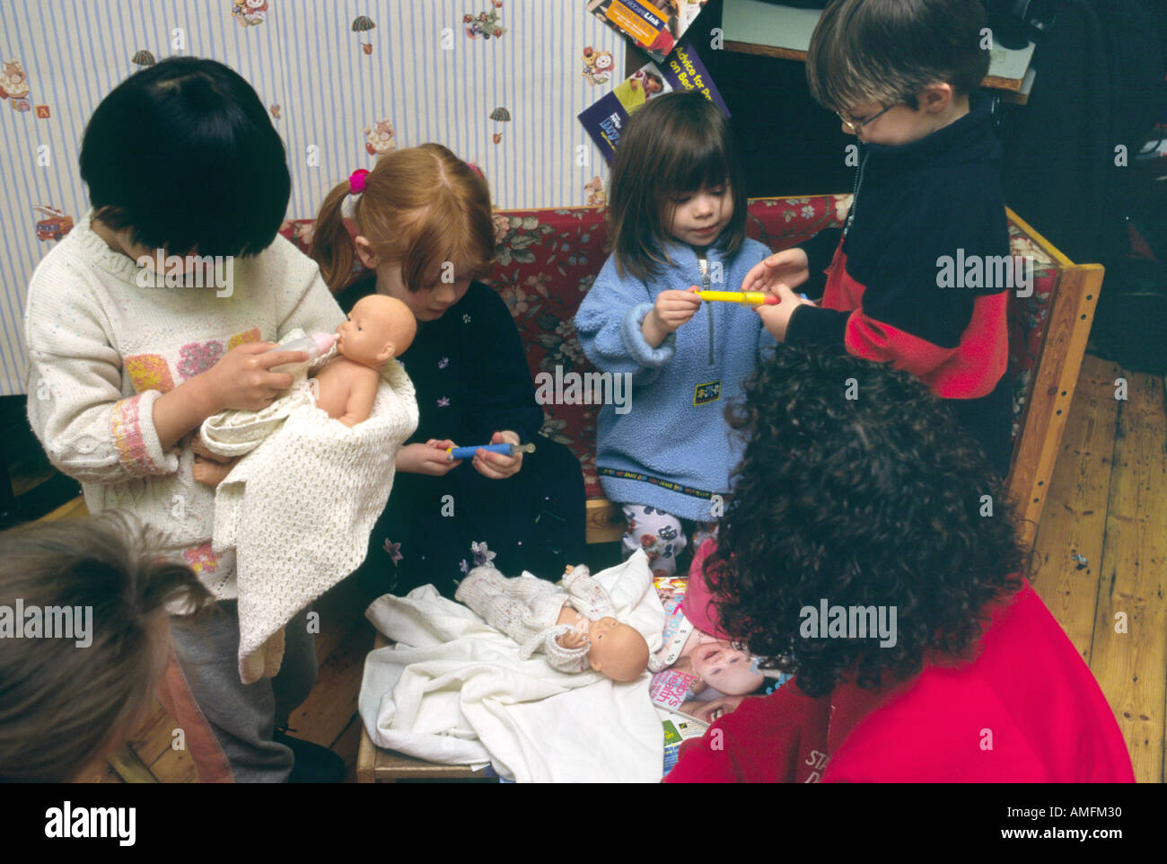 Bambini della scuola materna a giocare con le bambole Foto Stock