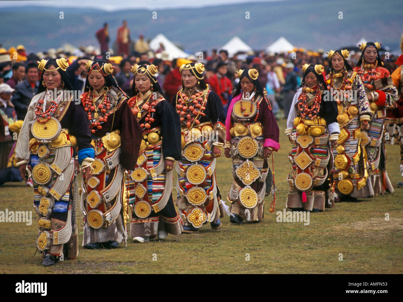 Femmina usura Khampas oro pezzi capelli scatole gau zee pietre corallo a Litang Horse Festival nella provincia del Sichuan in Cina Foto Stock