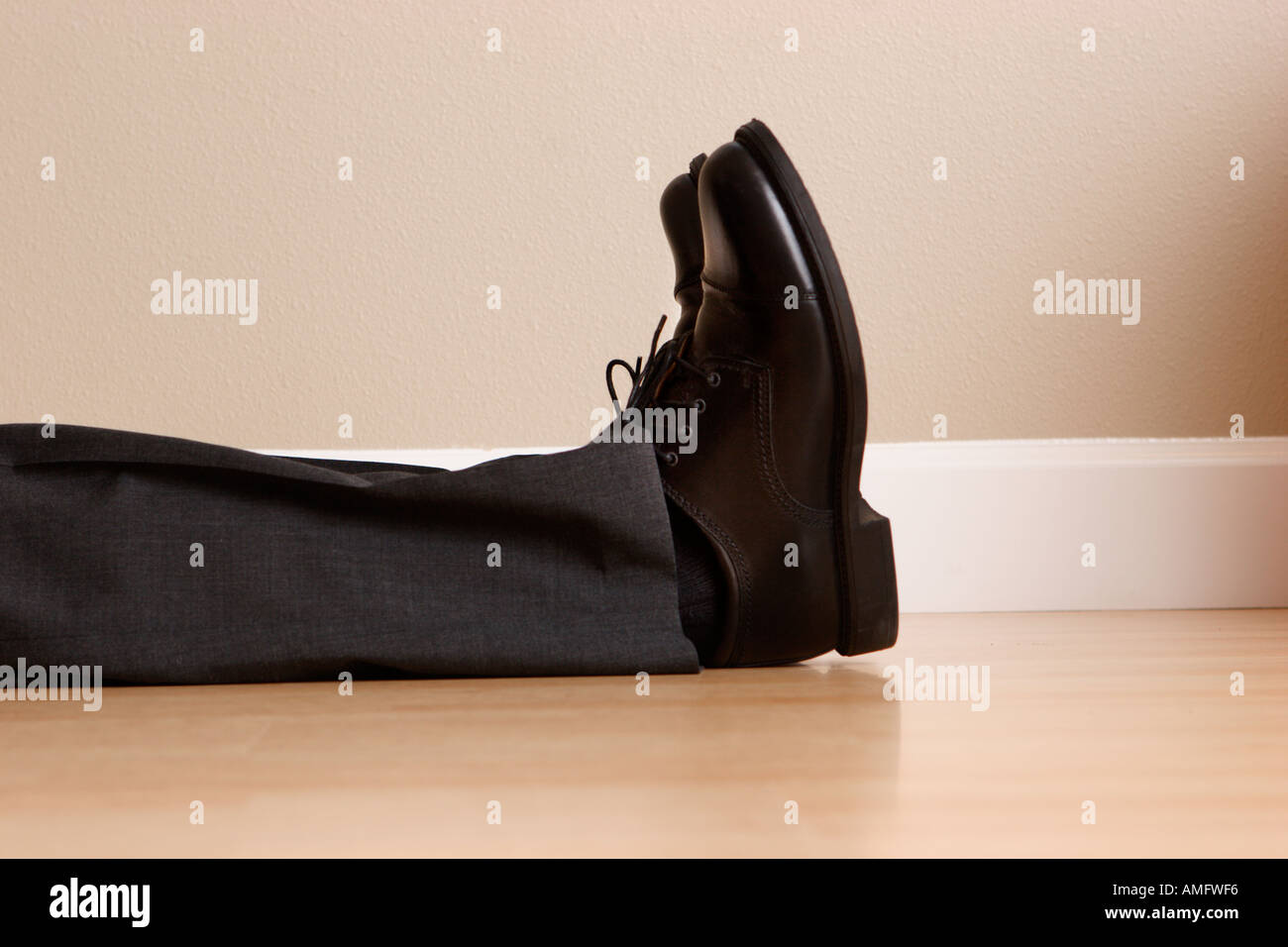 Imprenditore giacente sul piano solo con gambe e piedi in mostra Foto Stock