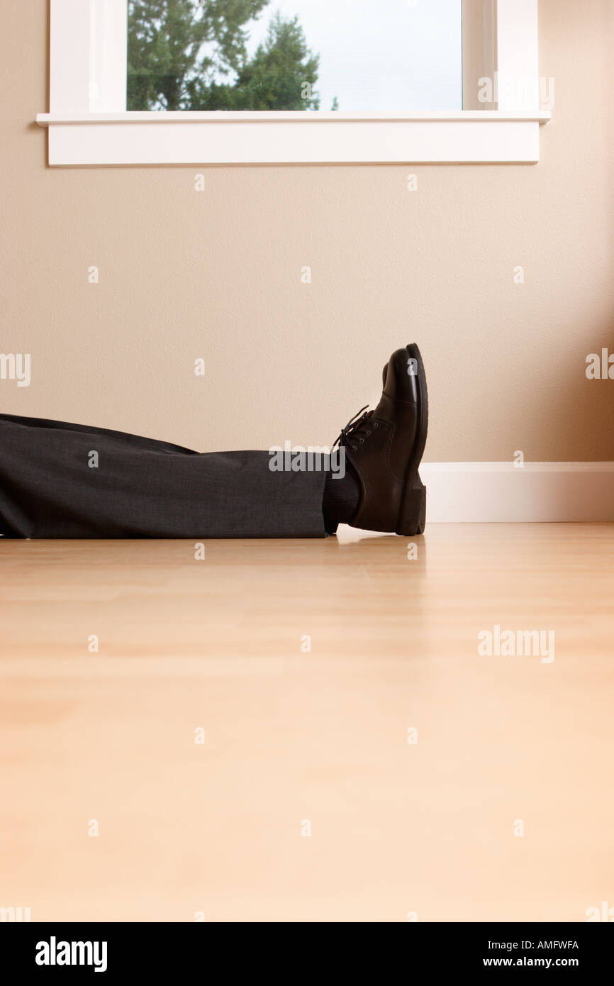 Imprenditore giacente sul piano solo con gambe e piedi in mostra Foto Stock