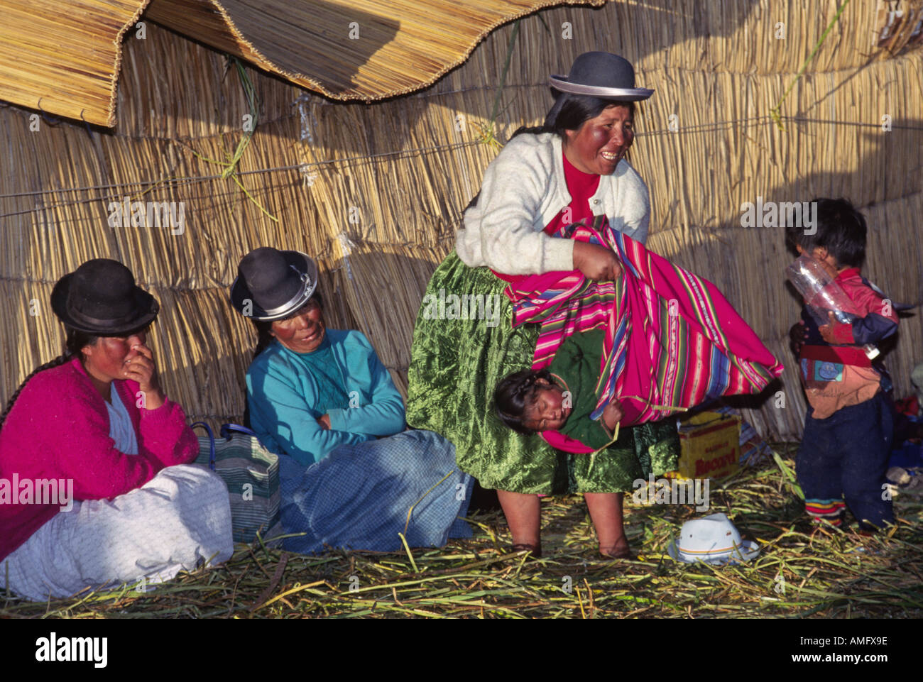 Donna AYMARA montacarichi baby a una festa di nozze sulla principale isola galleggiante del lago Titicaca in Perù Foto Stock