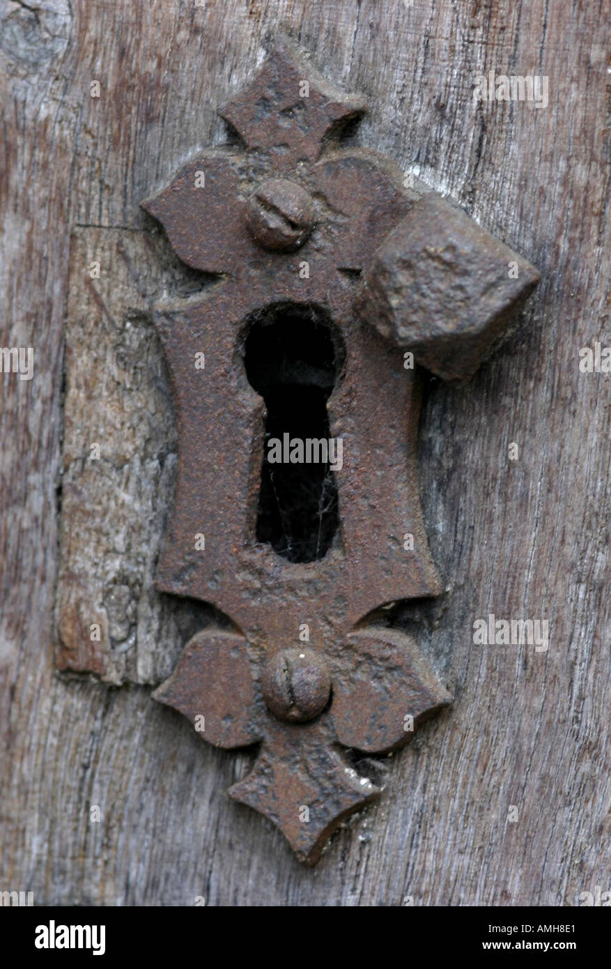 Un vecchio arrugginito sul buco della serratura di una porta di legno Foto Stock