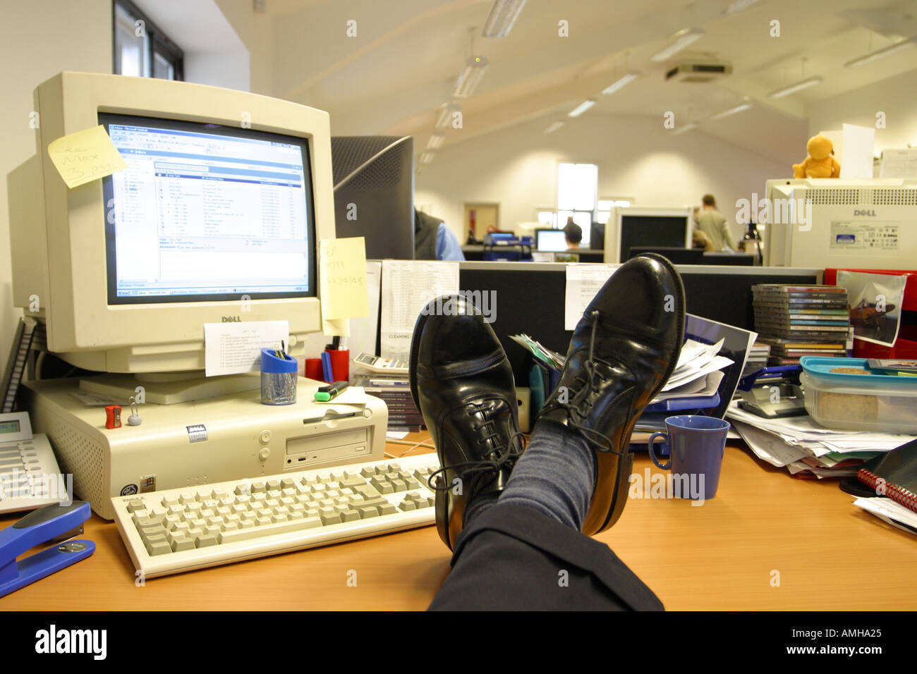 Lavoratore di ufficio con piedi tenendo rilassato è facile sul desktop durante il lavoro Foto Stock