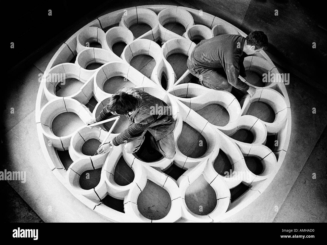 Muratori lavorano sul calcare tracery per una navata di rose finestra alla Cattedrale di Portsmouth, Regno Unito. Foto Stock