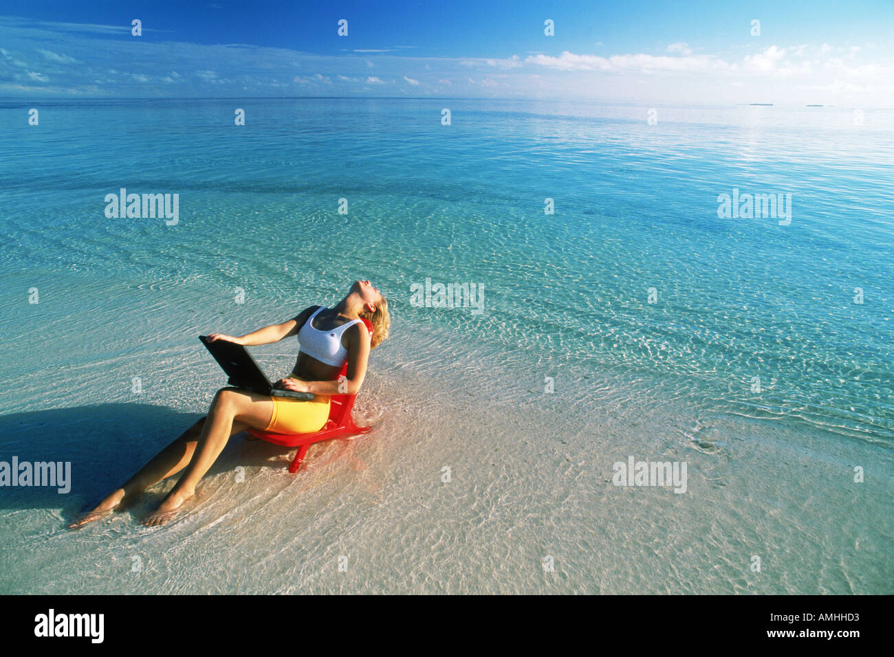 Donna sul lavoro vacanze in spiaggia sedia con computer portatile in Maldive Foto Stock