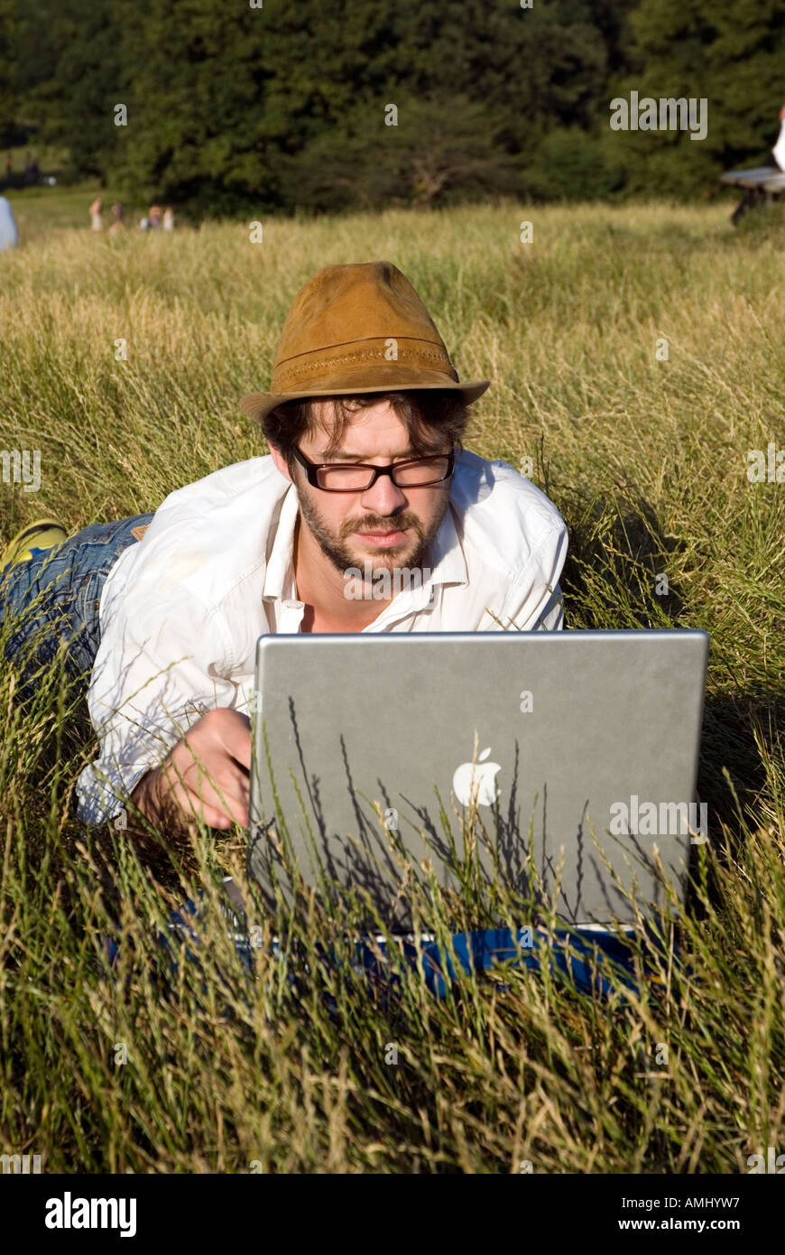 Uomo che utilizza un computer portatile Apple all'aperto su Hampstead Heath, London, Regno Unito Foto Stock