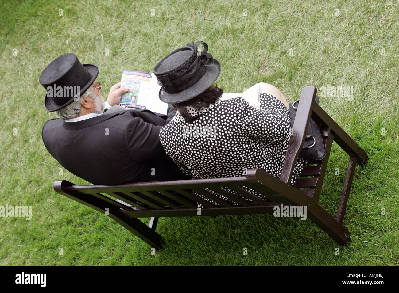 L uomo e la donna seduta su una panchina presso il Royal Ascot cavallo di razza, York, Gran Bretagna Foto Stock
