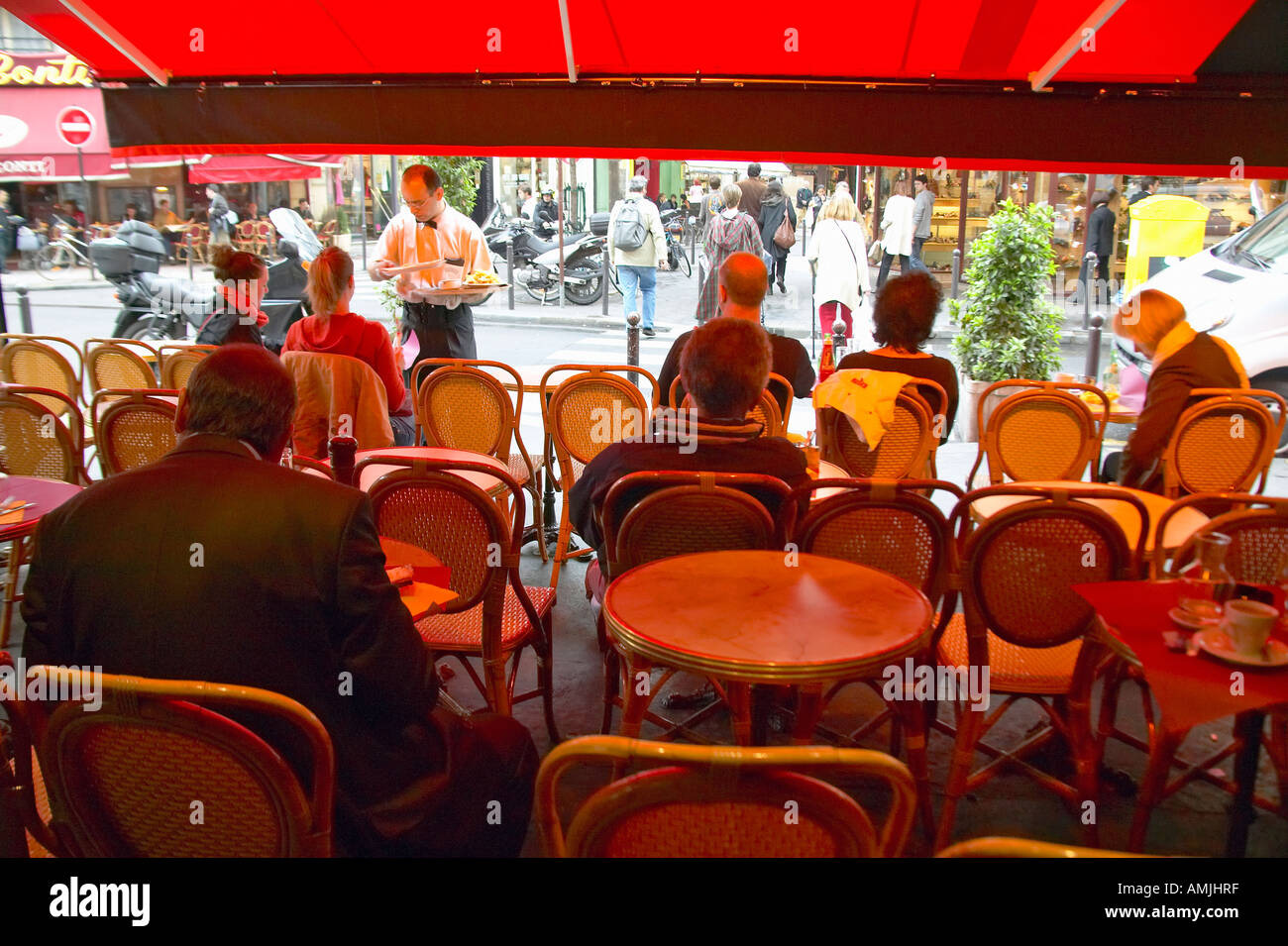 Posti a sedere esterni sotto la tenda presso il café Parigi Francia Foto Stock