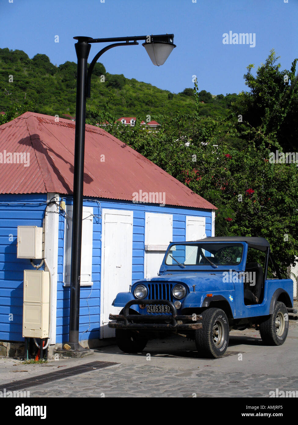 Blu casa in legno con stagno rosso tetto persiane bianche e quattro ruote motrici esterno Gustavia St Barts Foto Stock