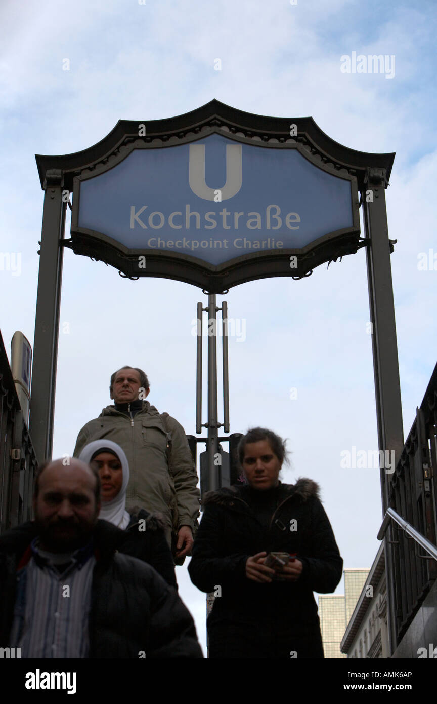 Persone che camminano giù passi a Kochstrasse; la stazione U-bahn firmare il Checkpoint Charlie Berlino Germania Foto Stock