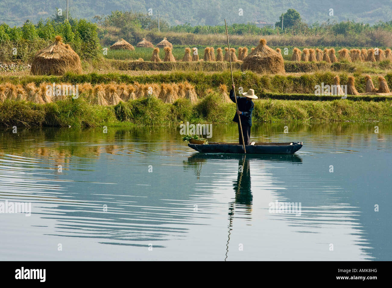 L'agricoltore cinese su una zattera di bamboo in Li Jiang fiume pietre calcaree carsiche Yangshuo Cina provincia di Guangxi Foto Stock