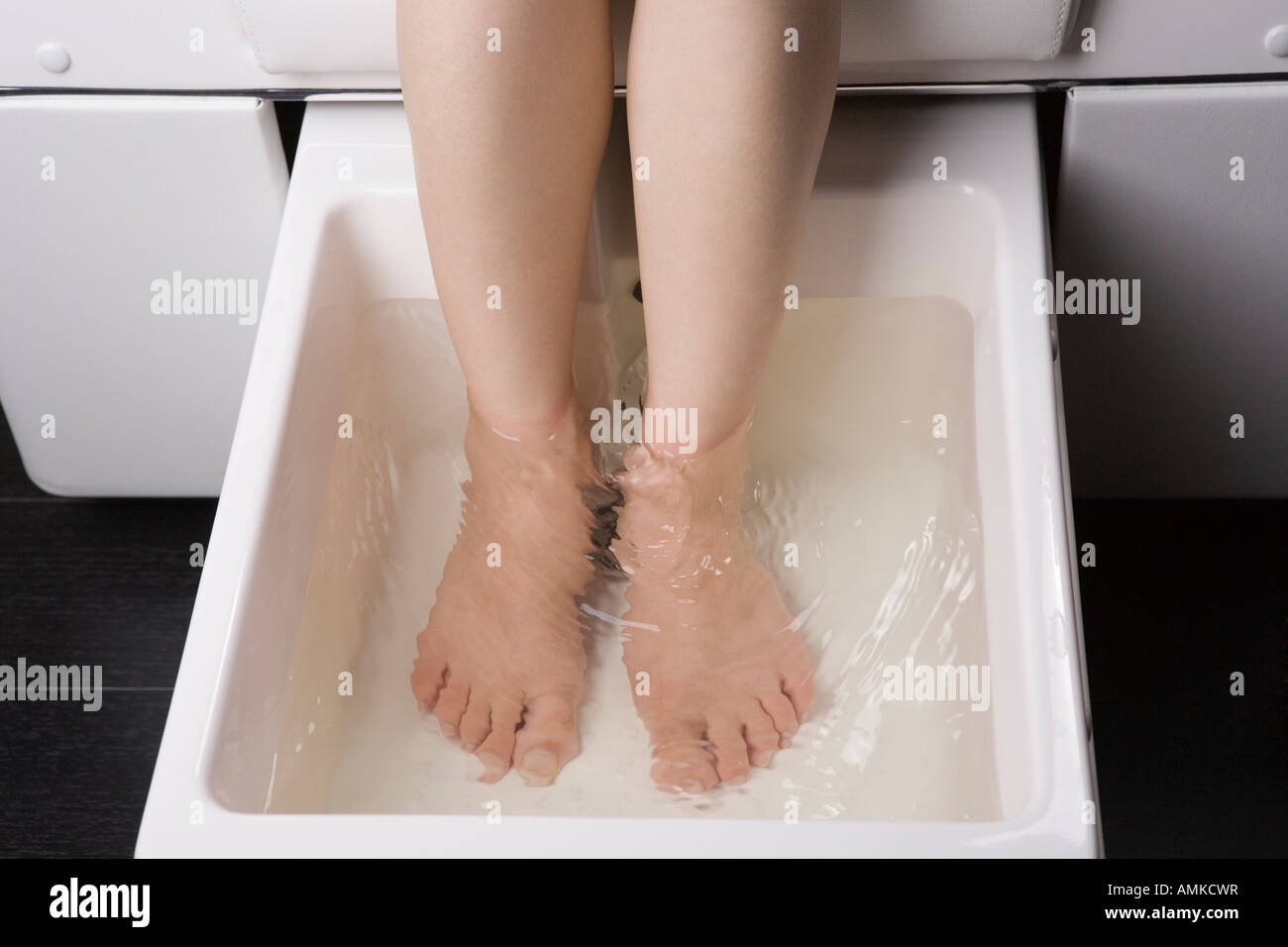 Giovane donna con piede bagno Foto Stock