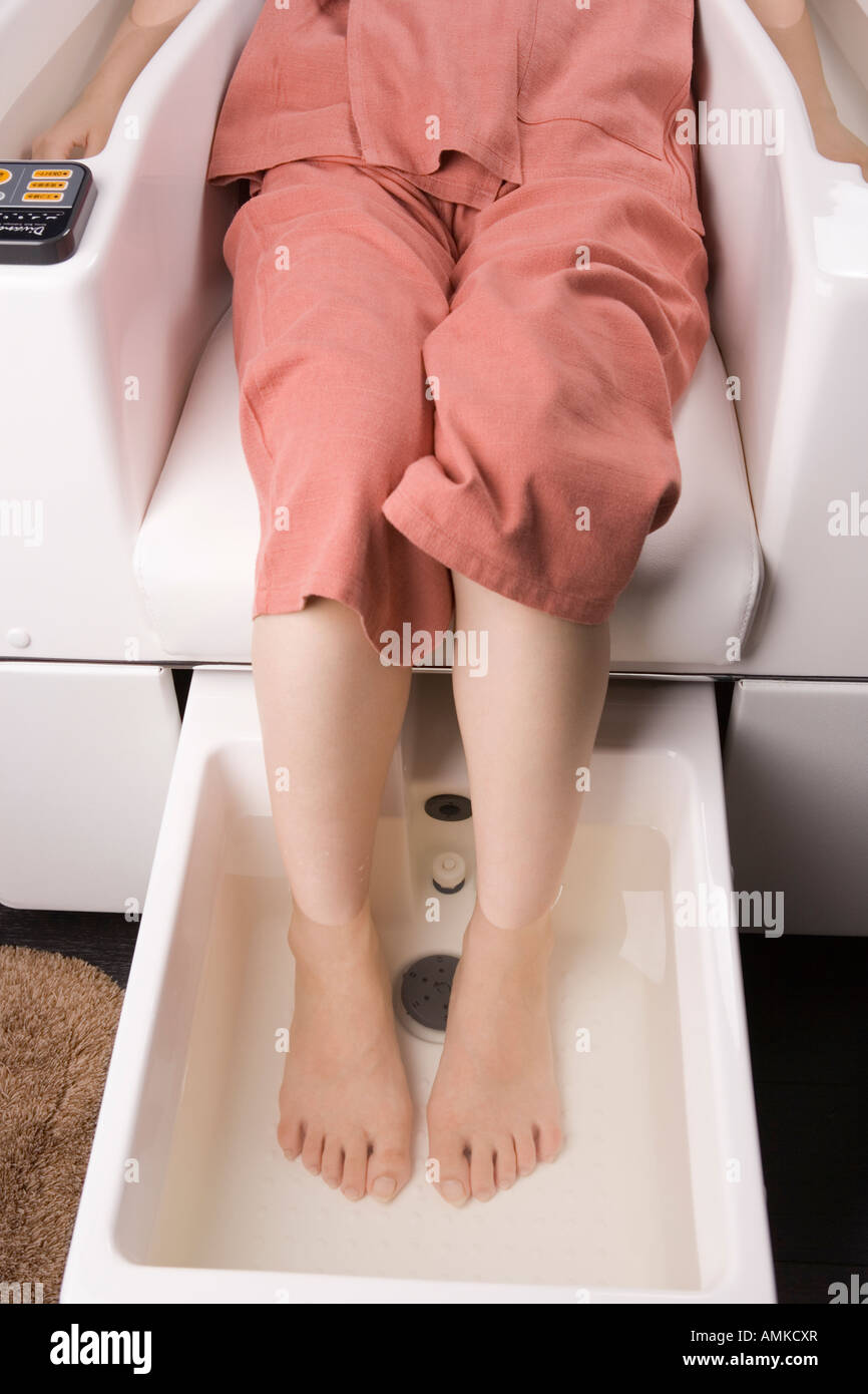 Giovane donna con piede bagno Foto Stock