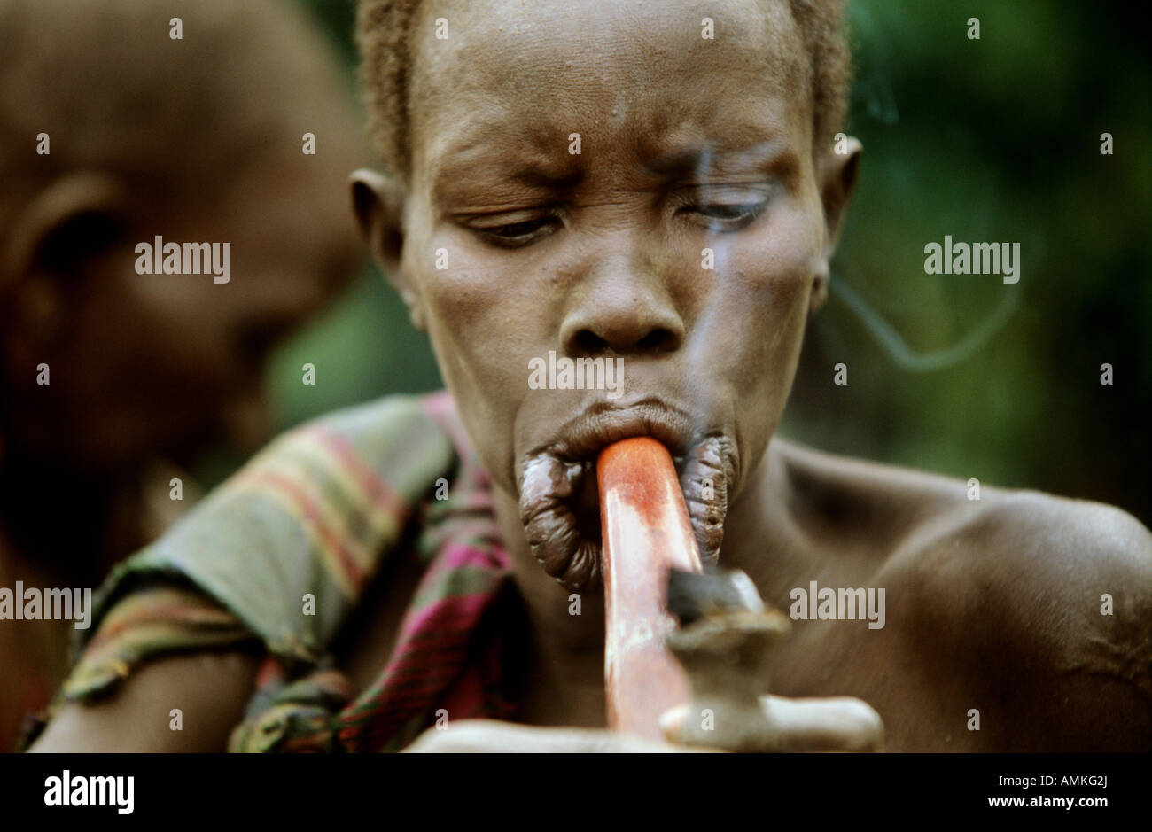Una donna surma fumi dalla loro tradizionale tubo Foto Stock
