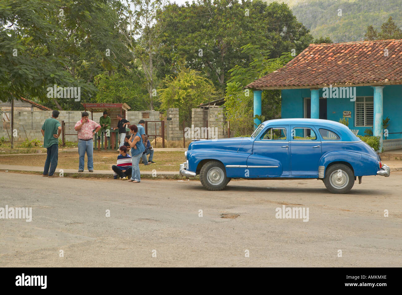 Le vecchie autovetture e tre persone nel villaggio cubano in rurale di Cuba centrale Foto Stock