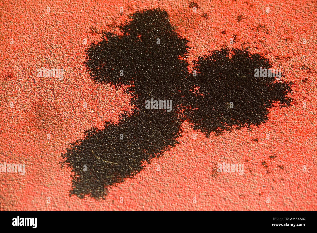 Una perdita di olio sul rosso tarmac in un parcheggio a Leicester Regno Unito Foto Stock