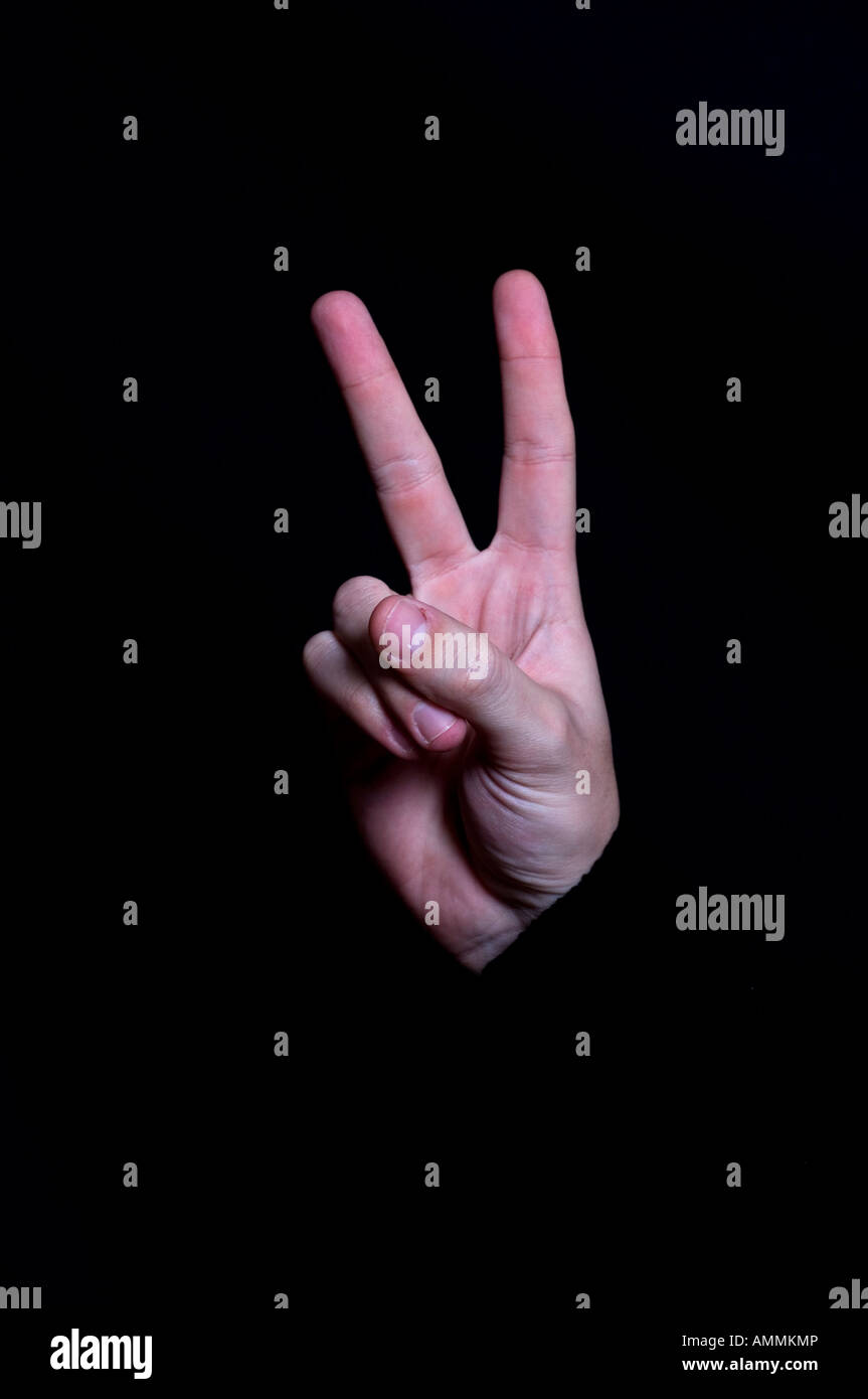 La mano che mostra segni di pace gesto Foto Stock