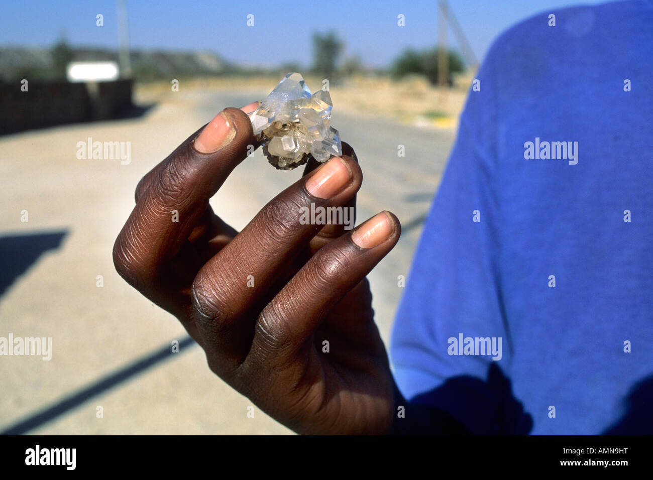 Una chiusura di un uomo in possesso di un cristallo di quarzo, semi-gemma preziosa in ui Foto Stock