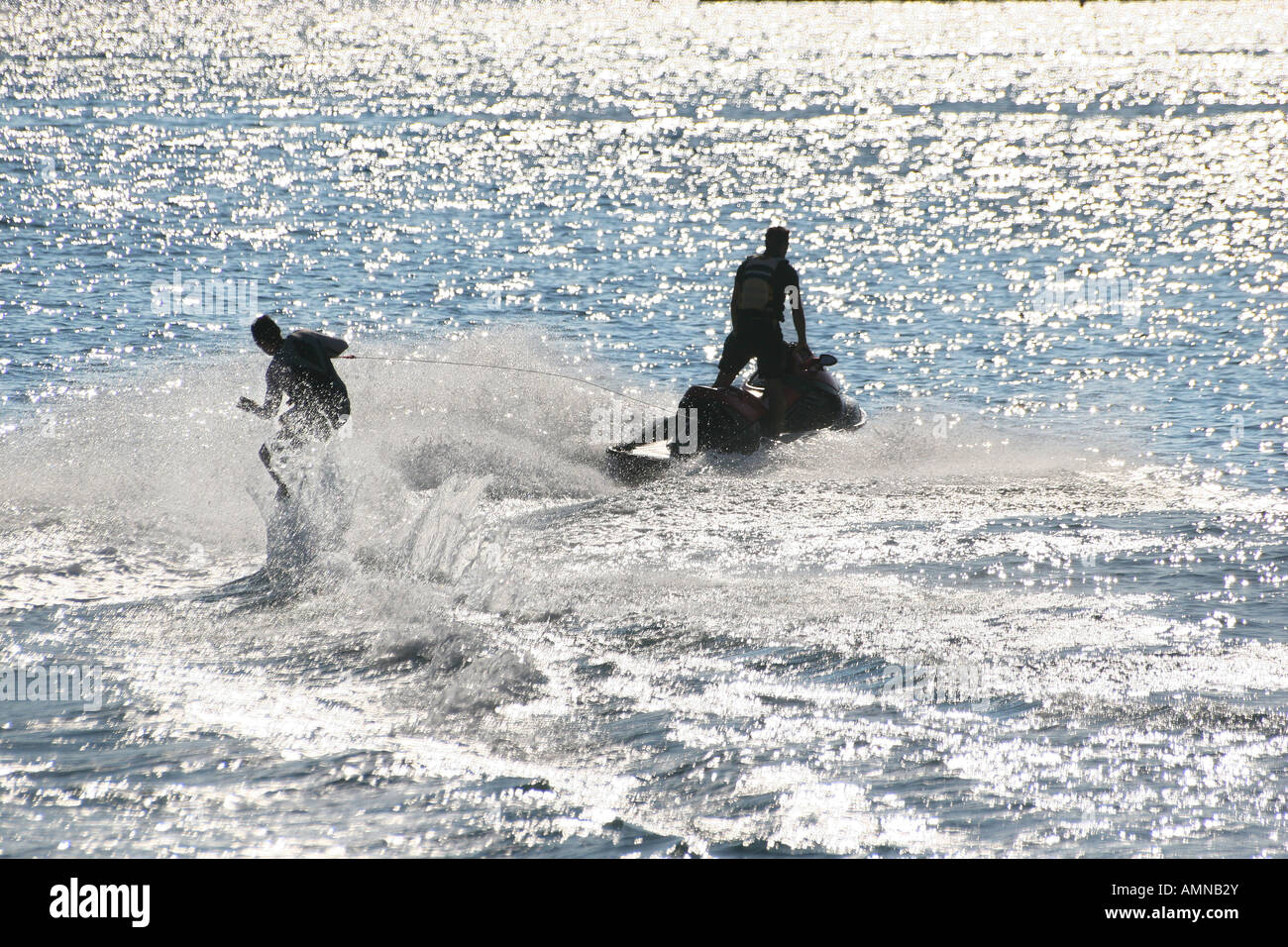 Silhouette di uomo sking acqua ad alta velocità in Palma Nova trainato da un getto di acqua bike. Foto Stock