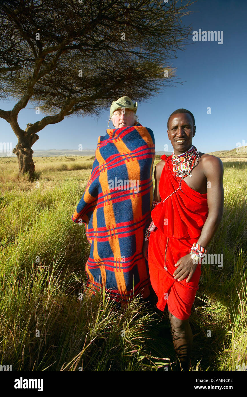 Peter Bender in Senior Elder robe e guerriero Masai in piedi nei pressi di Acacia nel Lewa Conservancy del Kenya Africa Foto Stock