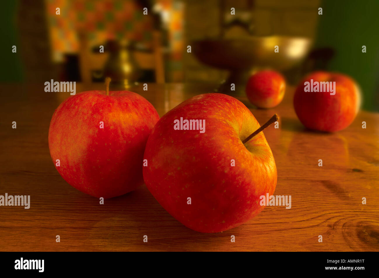 Mele rosse su una tavola di pino in una cucina Foto Stock