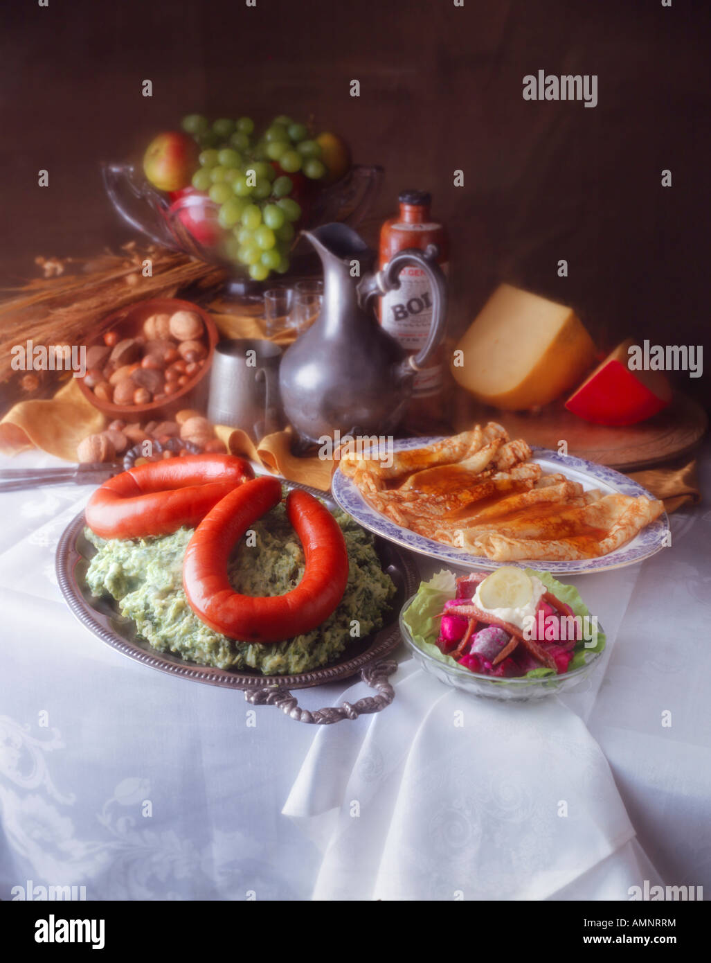 Tabella di cucina olandese. Franjfurt sulla mescolanza di cavolo con frittelle allo sciroppo. Formaggio olandese e frutta e noci. Scattato come una pittura olandese Foto Stock