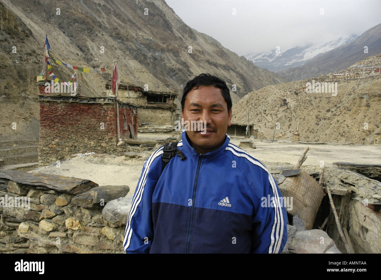 Sherpa con una camicia Addidas sul tetto di una casa di Phu Nar Phu Regione Annapurna Nepal Foto Stock