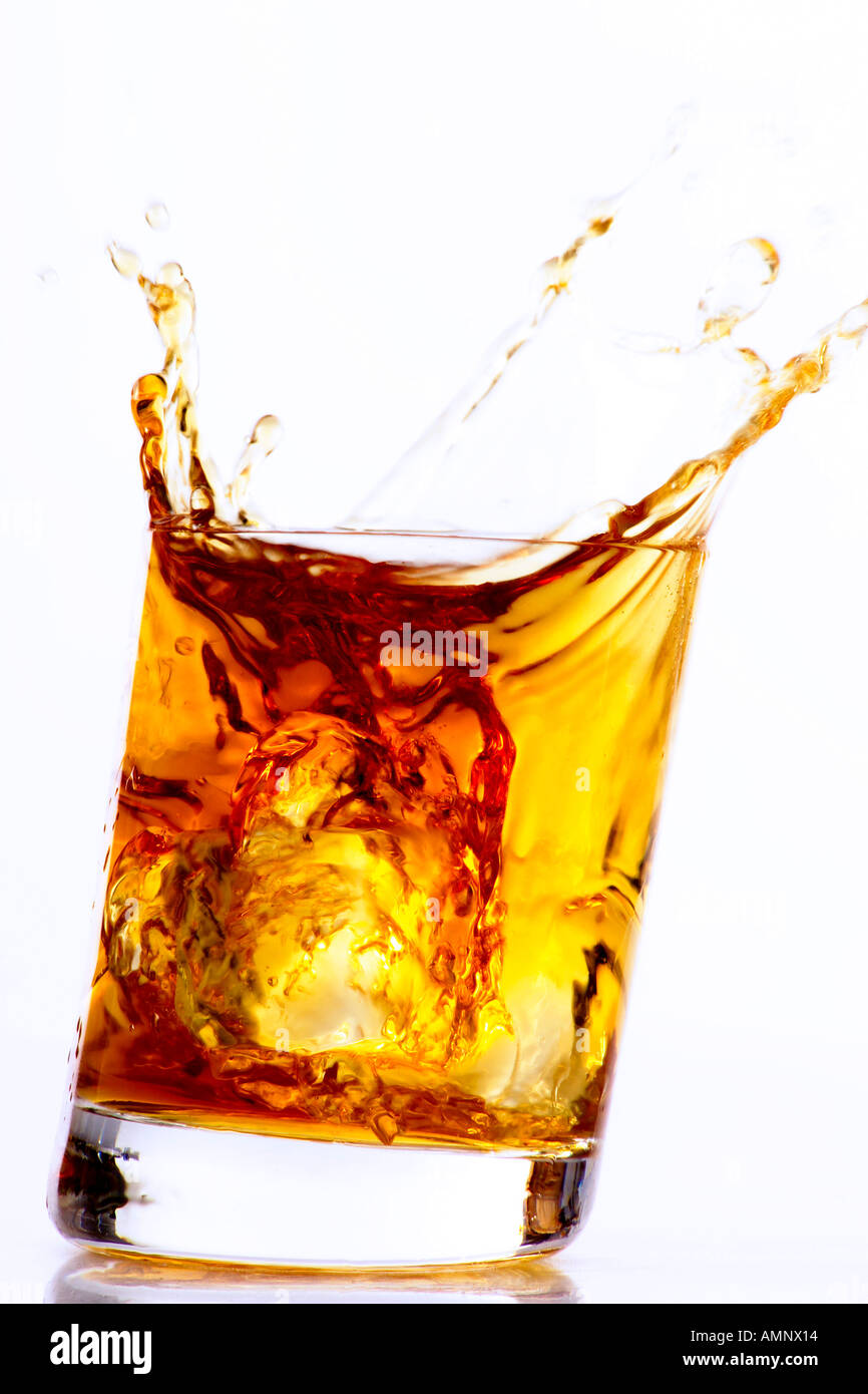 Il cubo di ghiaccio cadere nel bicchiere di Whiskey Foto Stock