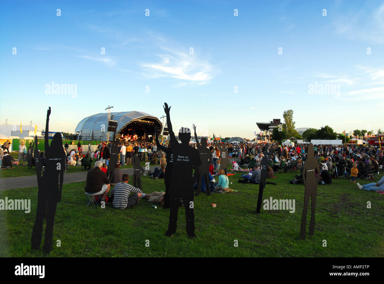 Intaglio figure punta verso il cielo e la folla di gente alla Wychwood Festival 2006 Foto Stock