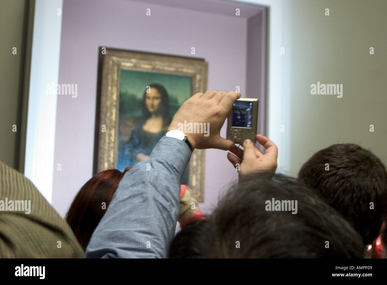Un visitatore assume un'istantanea digitale del famoso ritratto di Mona Lisa sul display del Louvre Parigi Francia Foto Stock