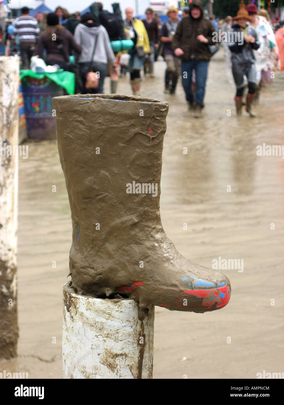 Fango incrostato wellington boot sorgeva sul post con mare di fango in background a Glastonbury festival 2007 Foto Stock