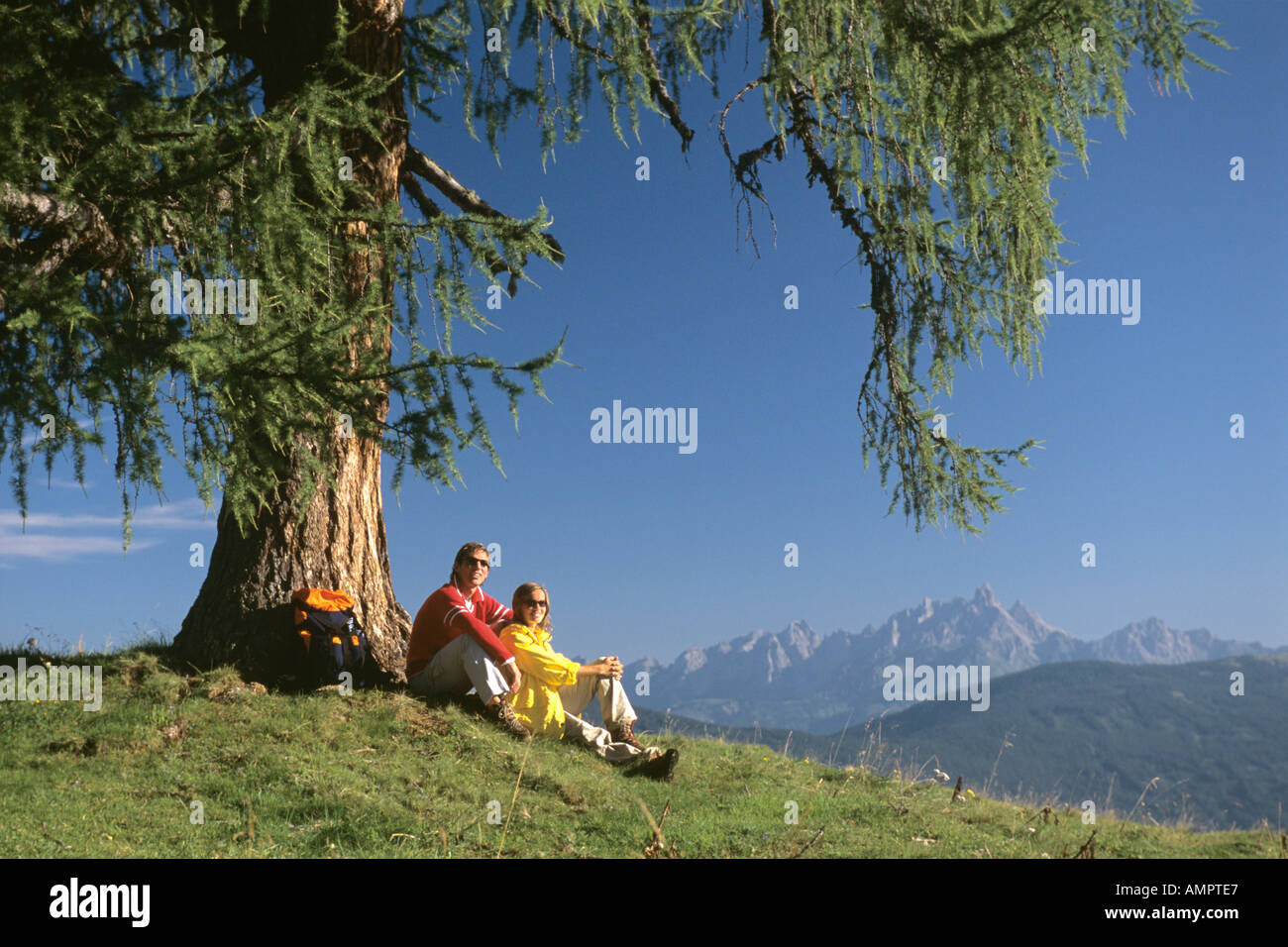 Coppia di rottura sotto agli alberi in montagna Foto Stock