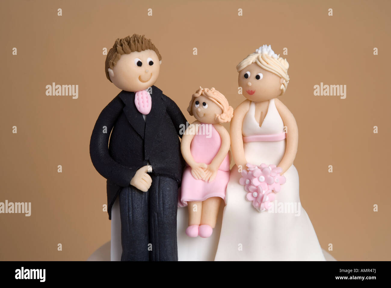 Il marito e la moglie si accoppiano sulla torta di nozze con un bambino Foto Stock