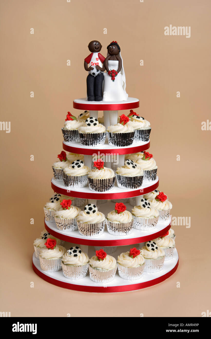 Calciatore nero il marito e la moglie giovane sulla torta nuziale. Foto Stock