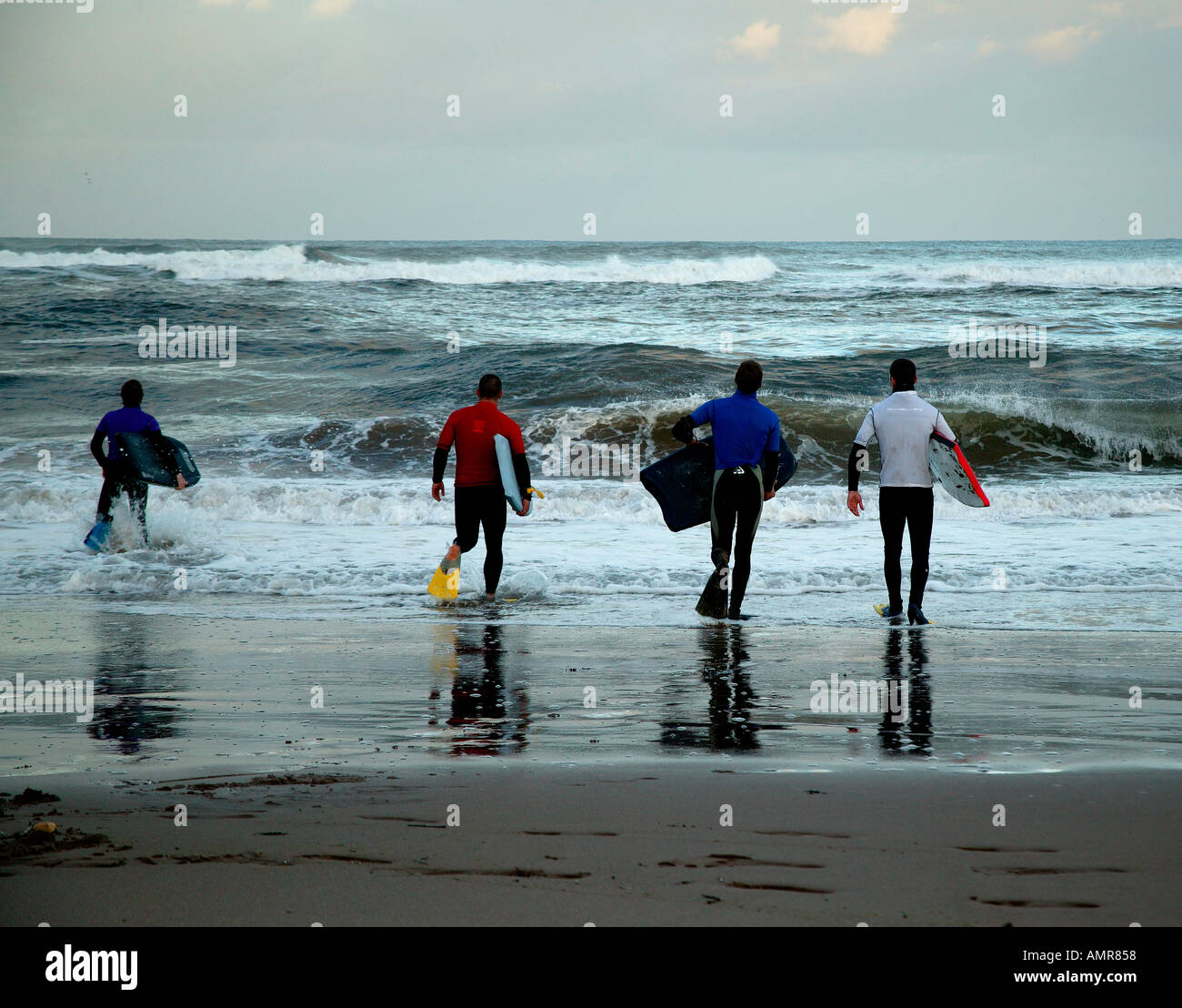 Corpo surfers la rubrica nel Mare del Nord Scozia costa est per una sessione di surf Foto Stock